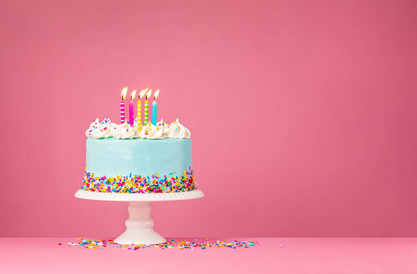 Голубой пирог с пятью свечами на розовом фоне