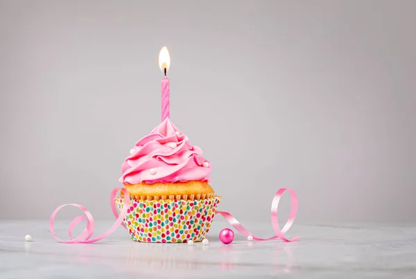 Cupcake de cumpleaños rosa con vela sobre fondo gris —  Fotos de Stock