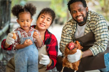 Afrikalı karı koca portresi çocuklara çiftlikte tavuk yetiştirmeyi öğretiyor.
