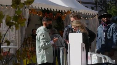 10 Ekim 2021 - Strasbourg, Fransa: Özel e-yeşil aşı e-pasaportlarıyla fuara giriş. Çitlerin önündeki girişteki güvenlik görevlisi covid-19 aşılarını kontrol ediyor.