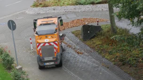 Kehl, Allemagne - 5 octobre 2021 : Un concierge avec une machine spéciale qui enlève les feuilles jaunes tombées des rues nettoie la zone — Video