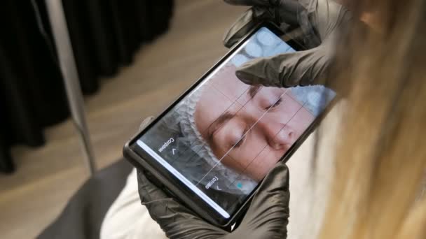 7 de setembro de 2019 - Kamenskoye, Ucrânia: Programa especial no smartphone que permite determinar a forma correta das sobrancelhas ao longo do contorno do crânio. Microblading, tatuagem permanente — Vídeo de Stock