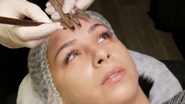 7 de septiembre de 2019 - Kamenskoye, Ucrania: Una hermosa niña mide la forma de sus cejas usando un divisor especial o brújula. Cejas de Microblading en estudio de belleza. — Vídeos de Stock