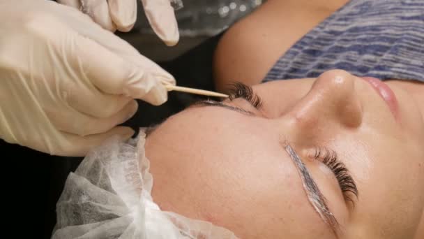 Перед процедурой мастер применяет специальную анестезию. Коррекция формы бровей. Микролезвие, постоянный макияж, татуировка — стоковое видео
