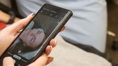 7 Eylül 2019 - Kamenskoye, Ukrayna: müşteriye yeni kaş biçimi. Usta, kadının yüzünün fotoğrafını çekiyor ve Rusça telefon yazısında yeni mikropatenli kaşlar var.
