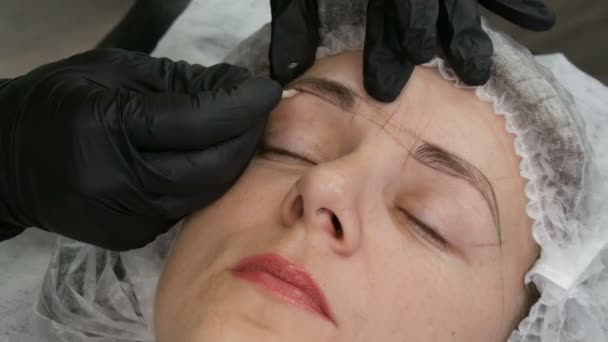 Measure the shape of new eyebrows with special dyed thread. Microblading, permanent makeup, tattoo, Face contour — Stock Video