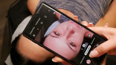 7 Eylül 2019 - Kamenskoye, Ukrayna: müşteriye yeni kaş biçimi. Usta, kadının yüzünün fotoğrafını çekiyor ve Rusça telefon yazısında yeni mikropatenli kaşlar var.