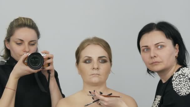 Make-up-Artist macht ein helles Abend-Make-up und ihr Kunde, der Videograf, schießt reflektiert in den Spiegel in die Kamera — Stockvideo