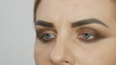 Profesyonel akşam makyajı, özel bir fırça kaş şeklini değiştirir. Makyöz, genç bir kadın mankene kaş çizer.