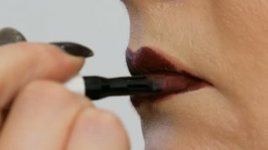 Profesyonel usta makyaj sanatçısı güzellik salonunda özel fırça ve makyaj dumanlı gözleri ile model ince dudaklar koyu kırmızı ruj uygular