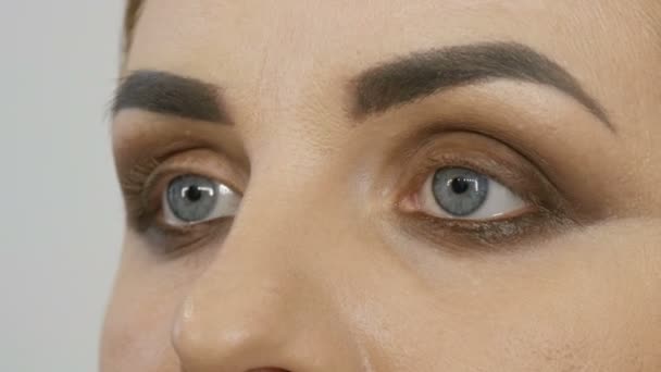 Professionell kvällssmink, en speciell borste ändrar formen på ögonbrynen. Makeup artist drar ögonbryn till en ung kvinna modell — Stockvideo