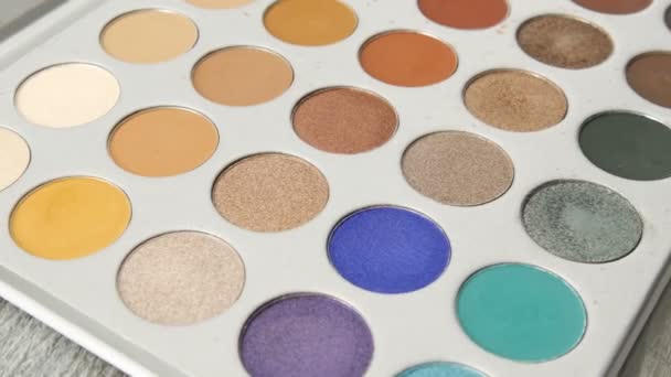 Paleta de conjuntos multicoloridos com sombras em uma caixa especial. Cosméticos de maquiagem profissional — Vídeo de Stock