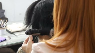 Saç bukleleri için özel sıcak ütü. Güzellik ve moda konsepti. Modelleme için Stilist Kullanma Aracı