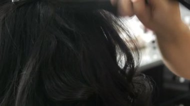 Kadın kuaför stilisti saç stili yapar. Saç spreyini sprey şişeye koymak için özel cila. Güzellik ve moda konsepti. Siyah saçlı..