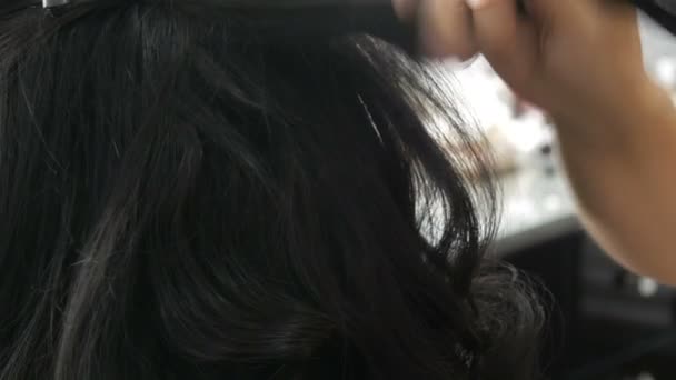 Žena kadeřnice stylistka dělá účes. Speciální lak na fixaci vlasů ve spreji. Krása a módní koncept. Černé vlasy. — Stock video