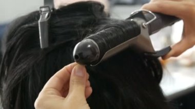 Saç bukleleri için özel sıcak ütü. Güzellik ve moda konsepti. Modelleme için Stilist Kullanma Aracı