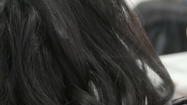 女性の美容師スタイリストは髪型を作ります。スプレーボトルで髪を固定するための特別なニス。美しさとファッションのコンセプト。黒髪. — ストック動画