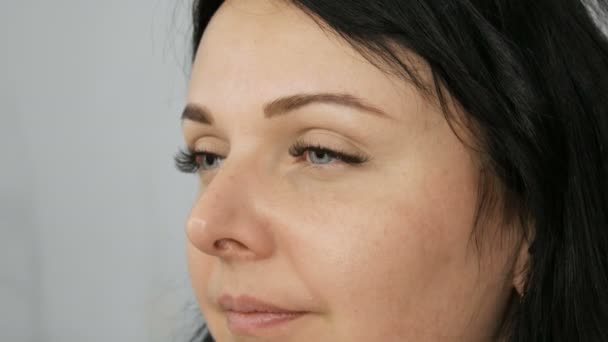 Maquillaje de ojos diario ligero de moda en tonos beige. El estilista con la ayuda de cepillos especiales hace que el maquillaje de ojos y la corrección de la forma de las cejas a un hermoso modelo de mujer joven de ojos azules — Vídeos de Stock