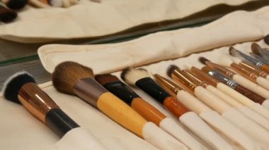 Profesyonel makyaj fırçaları takımı. Makyaj sanatçısı soyunma odasındaki masada özel bir fırça seti kullanır. Moda endüstrisi. Moda gösterisi kuliste