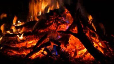 Karanlıkta yanan odunların üzerinde gökkuşağı mistik şenlik ateşi