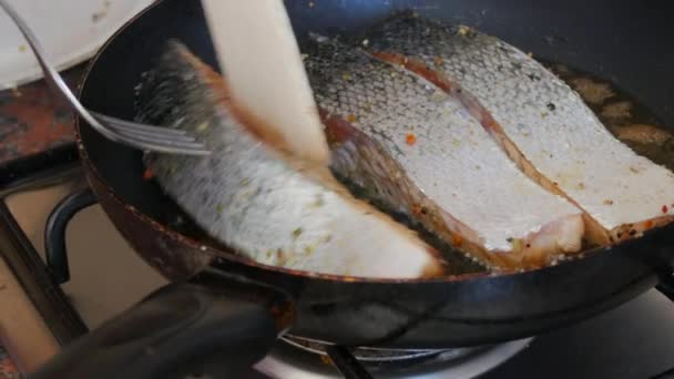 Filet z łososia czerwonej ryby solony i przyprawiony pieprzem smażonym na patelni obrócić z drewnianą łopatką kuchenną w kuchni domowej — Wideo stockowe