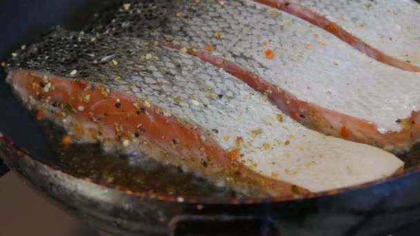 在自家厨房的平底锅里，用咸鱼片腌制，用胡椒煎过的红鱼调味，近距离观察 — 图库视频影像