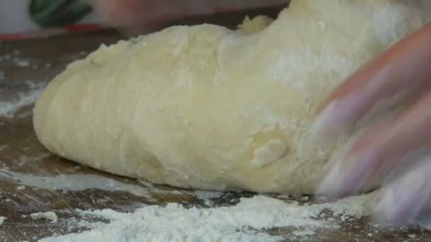 Vrouwen handen kneden het deeg voor thuis bakken chef-kok, gebak. Baker kneden deeg in bloem op tafel. Tarwe Zelfgemaakt Brood. Banketbakkerij. het begrip natuur, Italië, voeding, voeding en bio — Stockvideo