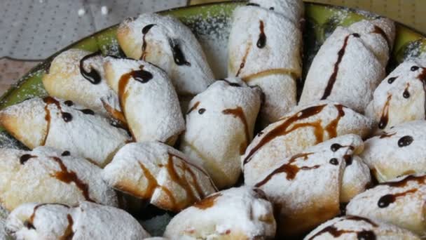 Hembakade bakverk, nybakade croissant bullar beströdda med pulversocker och flytande chokladglasyr i hemköket — Stockvideo