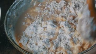 Ev mutfağındaki şeffaf bir konteynırda özel ahşap bir kaşık ile ev hamuru dizmek.