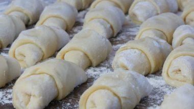 Ev yapımı hamur işleri, taze çörekler, kruvasanlar ve diğer taze hamur işleri ev mutfağındaki masada, fırında pişirmeye hazır.