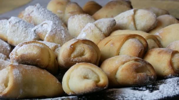 Pekař sype čerstvé croissanty s práškovým cukrem. Detailní záběr domácí domácí výroby a ručně dělané diy pekárny na velkém talíři v domácí kuchyni — Stock video
