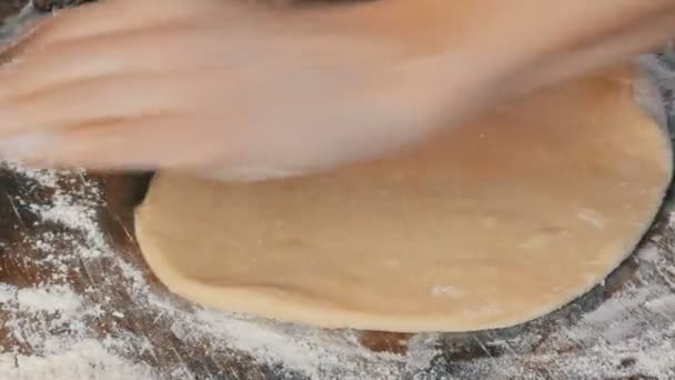 Las manos femeninas de los panaderos despliegan la masa con un delgado rodillo de madera en la cocina del hogar. Pasteles frescos caseros deliciosos de cerca vista . — Vídeo de stock
