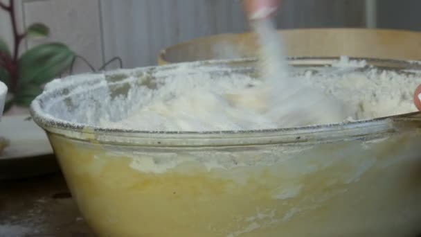 Térdelő házi tészta egy speciális fából készült sütőkanállal egy átlátszó tartályban az otthoni konyhában — Stock videók