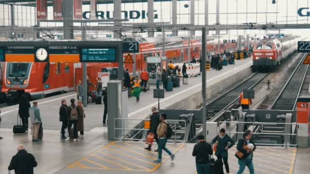 Мюнхен, Германия - 25 октября 2019 года: Главный железнодорожный вокзал. Поезд прибывает на платформу к ожидающим пассажирам — стоковое видео