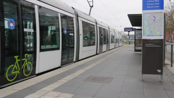 22 novembre 2021 - Kehl, Germania: Una folla di persone che indossano maschere mediche scende da un tram. Passeggeri alla fermata del tram che escono dalle porte aperte del trasporto pubblico — Video Stock