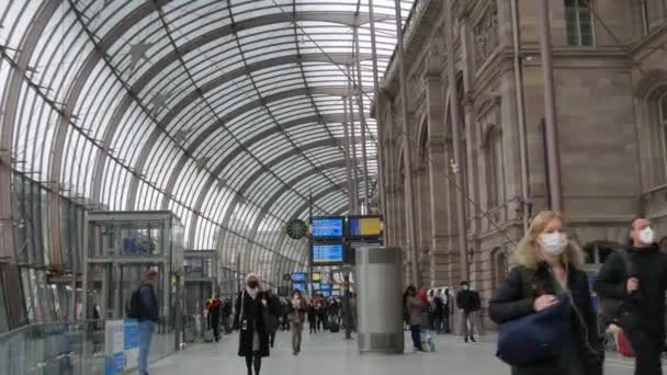 STRASBOURG, FRANKRIKE - NOVEMBER 22, 2021: Järnvägsstation, personer i medicinska masker med skydd mot spridning av covid19. Passagerare och hälsningar går genom tågstationen — Stockvideo