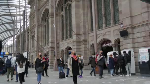 STRASBURG, FRANKRIJK - NOVEMBER 22, 2021: Treinstation, mensen met medische maskers met bescherming tegen de verspreiding van gezelschap19. Passagiers en groeten lopen door het treinstation — Stockvideo