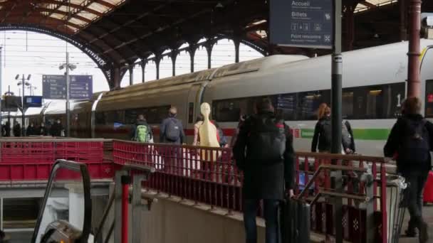 2021年11月22日，法国，斯特拉斯堡：火车站，戴着医疗面罩的人，以防止围攻的蔓延。乘客和乘客沿着月台散步 — 图库视频影像
