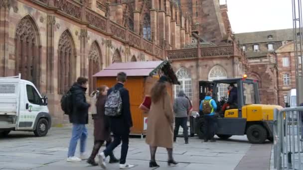 STRASBOURG, FRANCIA - 22 NOV 2021: Preparazione per i mercatini di Natale. Installazione di vassoi in legno utilizzando uno speciale mini trattore sulla piazza antistante la Cattedrale di Strasburgo — Video Stock