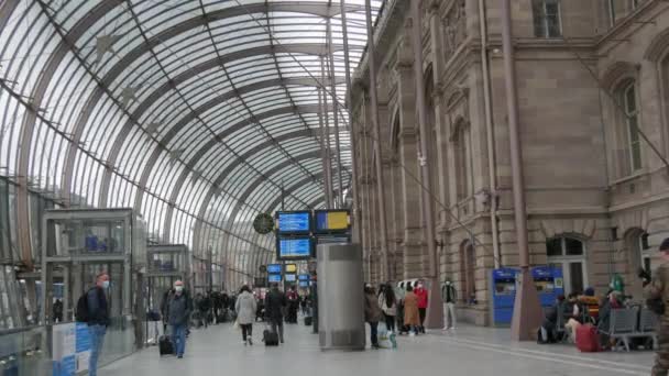 STRASBOURG, FRANKRIKE - NOVEMBER 22, 2021: Järnvägsstation, personer i medicinska masker med skydd mot spridning av covid19. Passagerare och hälsningar går genom tågstationen — Stockvideo