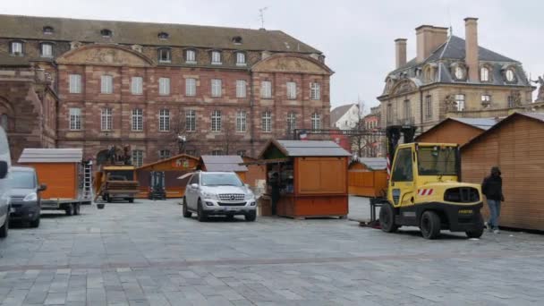 STRASBOURG,フランス- 2021年11月22日:クリスマスマーケットへの準備。世界で最も美しい見本市は、ストラスブール大聖堂の前の広場に木製の屋台を設置します。 — ストック動画