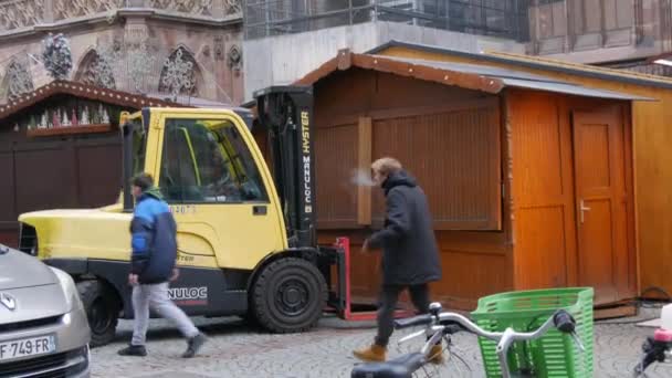 STRASBURG, FRANKRIKE - NOV 22, 2021: Förberedelse inför julmarknaderna. Installation av träbrickor med hjälp av en speciell minitraktor på torget framför Strasbourgs katedral — Stockvideo