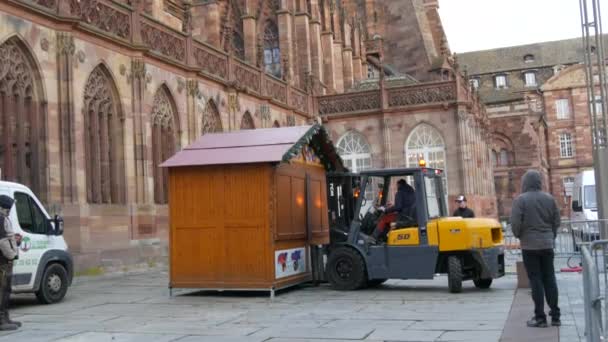 STRASBOURG, FRANCE - 22, 2021: Noel pazarına hazırlanıyor. Strasbourg Katedrali 'nin önündeki meydanda özel bir traktör kullanarak ahşap tepsilerin kurulumu — Stok video