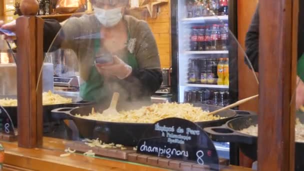 27. November 2021 - Straßburg, Frankreich: Weihnachtsmarkt, Menschen in medizinischen Masken stehen Schlange für leckeres Essen. Straßburg, die Welthauptstadt von Weihnachten. — Stockvideo