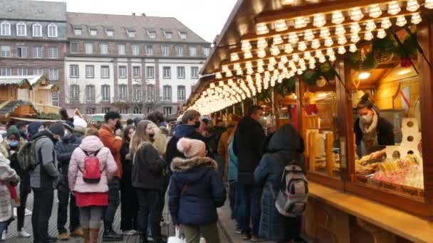 27 de novembro de 2021 Estrasburgo, França: Mercado de Natal, pessoas em máscaras médicas fazem fila para uma deliciosa comida. Estrasburgo a capital mundial do Natal. — Vídeo de Stock