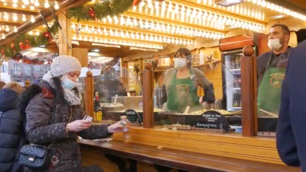 2021 년 11 월 27 일 - 프랑스 스트라스부르: 크리스마스 마켓, 의료용 마스크를 쓴 사람들 이 맛있는 음식을 찾아 줄지어 서 있다. 세계 크리스마스수도 스트라스부르. — 비디오