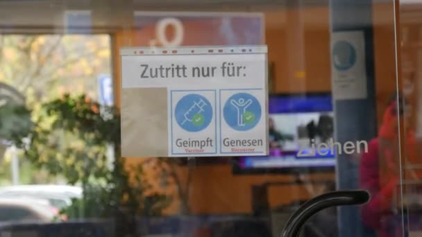 22 novembre 2021 - Kehl, Germania: Un cartello sulla porta di un caffè che permette l'ingresso solo ai vaccinati o vaccinati. Protezione contro la diffusione della congrega 19. Iscrizione in tedesco — Video Stock