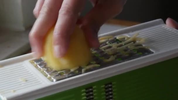 Mężczyzna ręce tarcie ziemniaki na a kuchnia tarka dla wegetariańskie jedzenie gotowanie — Wideo stockowe