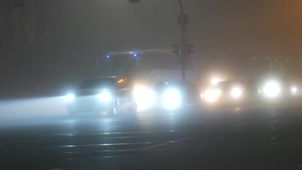 STRASBOURG, FRANKRIKE - NOV 6, 2021: Foggy höst kväll stad, bilar som kör längs gatan, strålkastare och dimljus på — Stockvideo