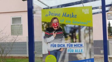 11 Aralık 2021 - Kehl, Almanya: Otobüs durağında COVID19 'a karşı maske isteyen bir poster, Almanca yazı. Grip Coronavirus 'a karşı mücadeleyi önlemek.